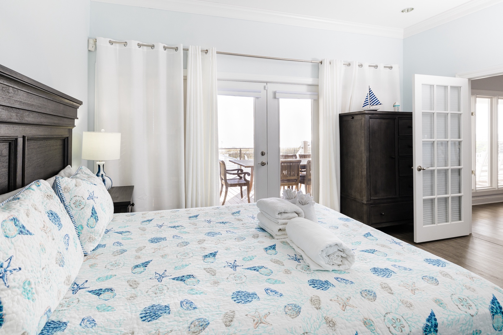 Wake up in your coastal-themed bedroom with crisp linens and natural light streaming through to your private balcony.