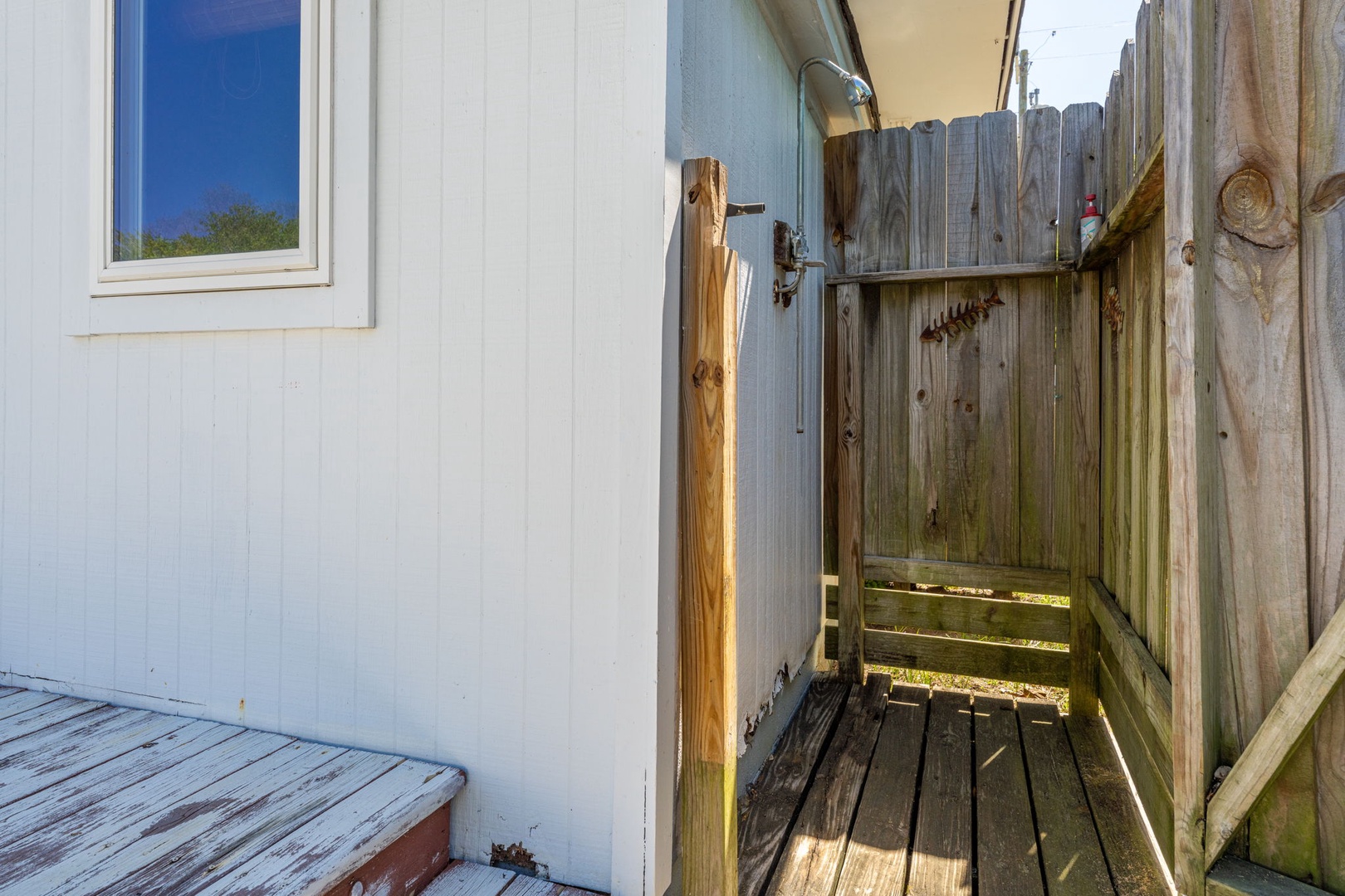 Step into your private outdoor shower where weathered wood meets open sky—a refreshing escape under the sun.