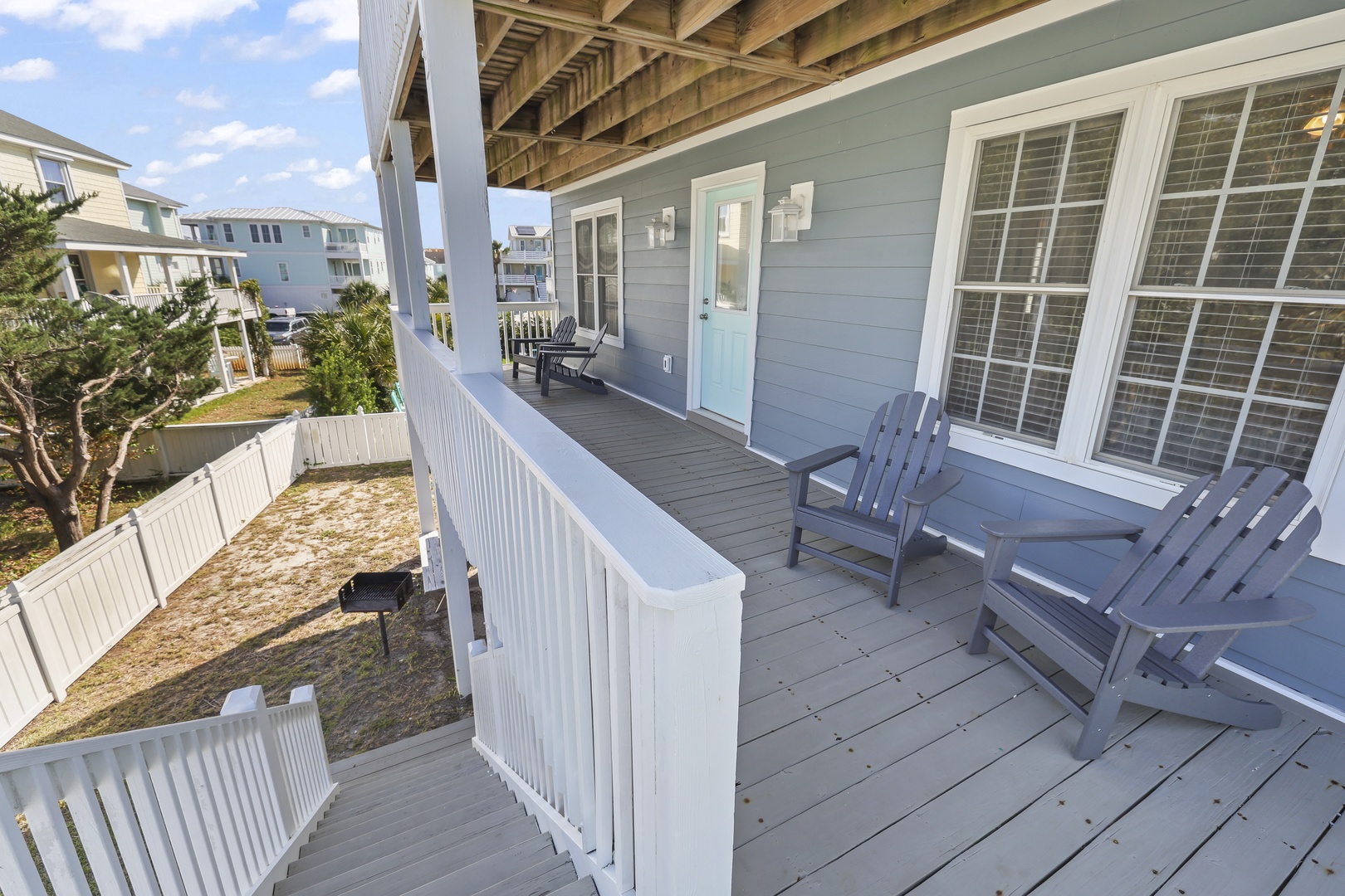 Relax on your private covered porch with coastal Adirondack seating, perfect for morning coffee or watching the neighborhood wind down after a beach day.