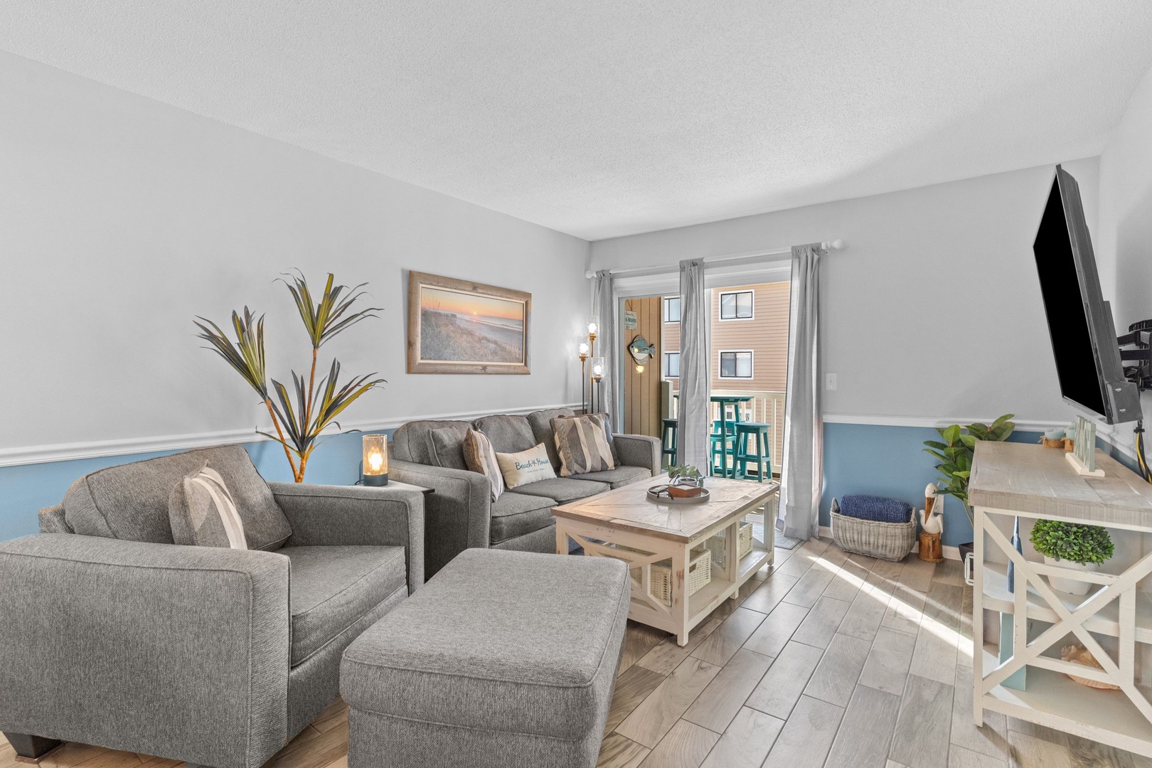 Unwind in your stylish living space with plush gray seating and coastal blue accents that create a soothing atmosphere.
