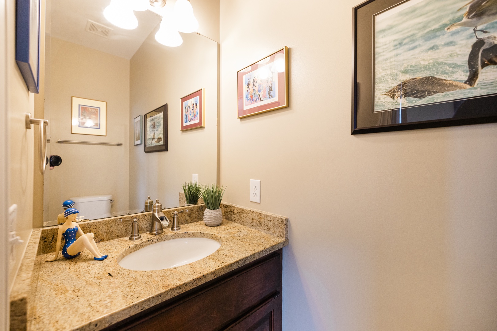 Freshen up in your private bathroom with granite counters, charming coastal artwork, and thoughtful amenities for your comfort.
