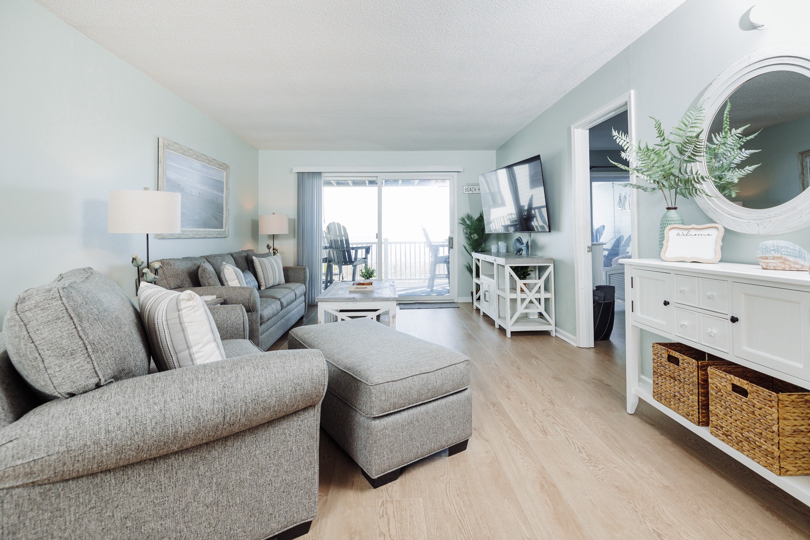 Sink into plush sofas and enjoy the coastal vibes in this bright living room, with your private balcony just steps away.