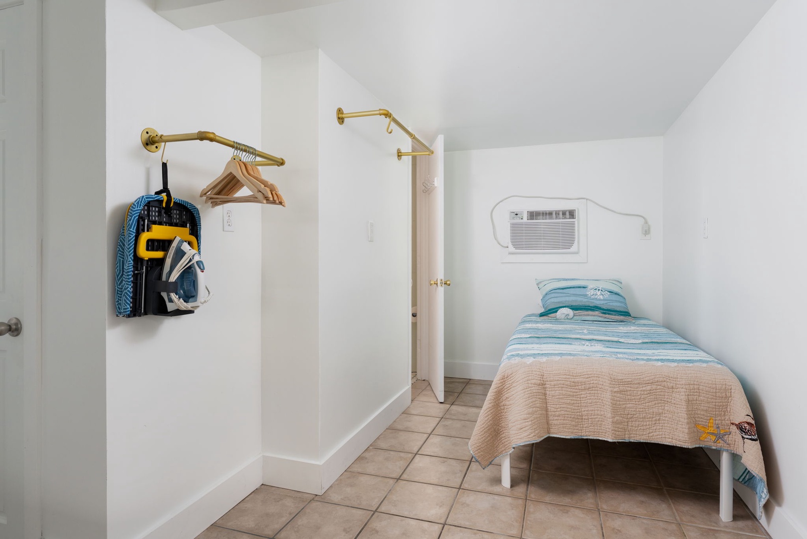 Your cozy bedroom retreat features a comfortable single bed and thoughtful touches like hangers and an AC unit for perfect comfort.