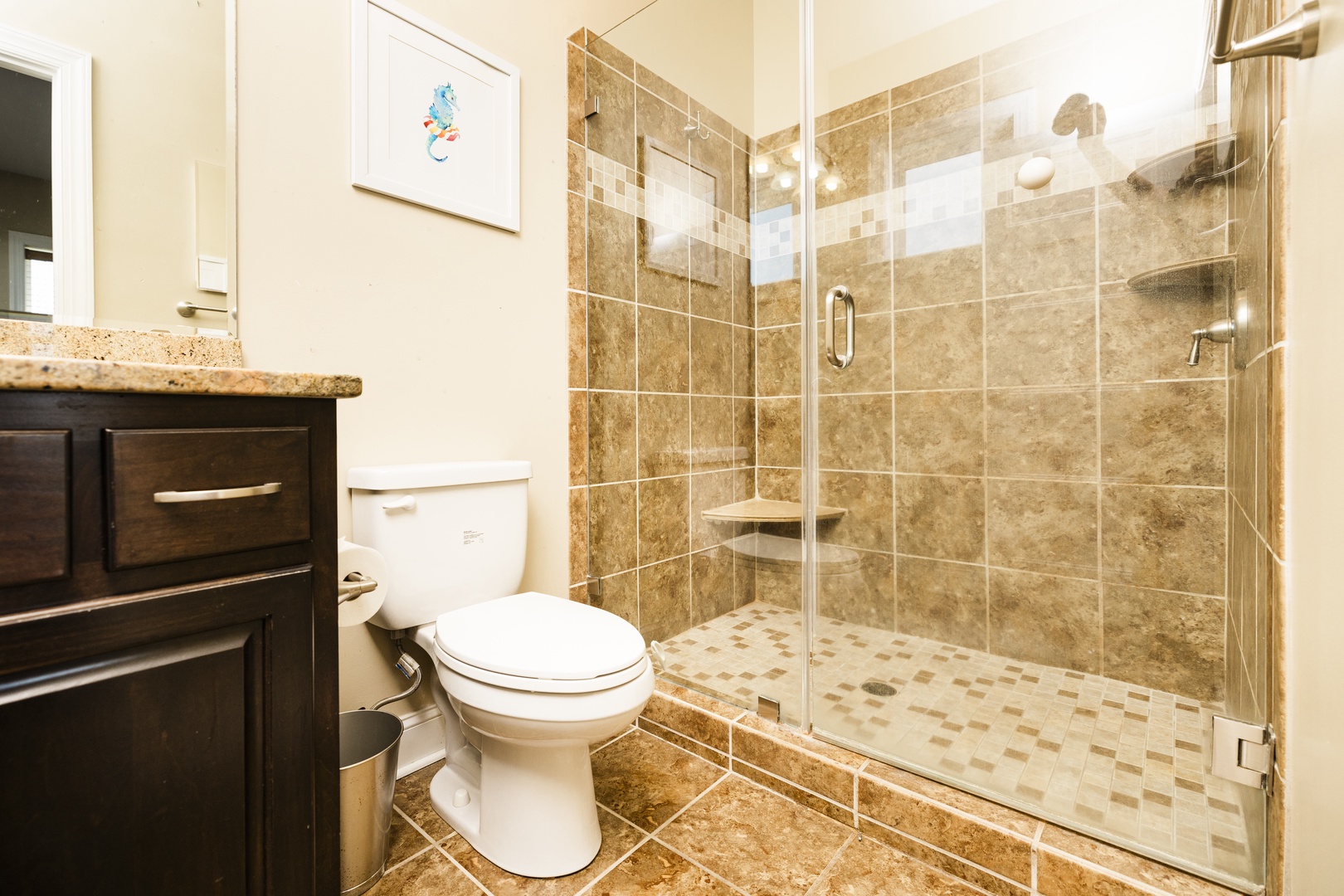 Step into your elegant bathroom with gleaming glass shower, rich stone tiles, and thoughtful amenities for a refreshing retreat.