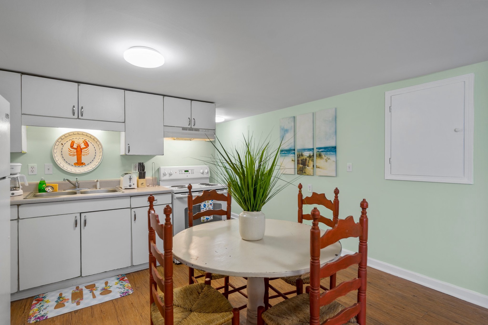 Your bright kitchen welcomes you with coastal charm, featuring a full dining table perfect for enjoying morning coffee or seaside-inspired meals together.