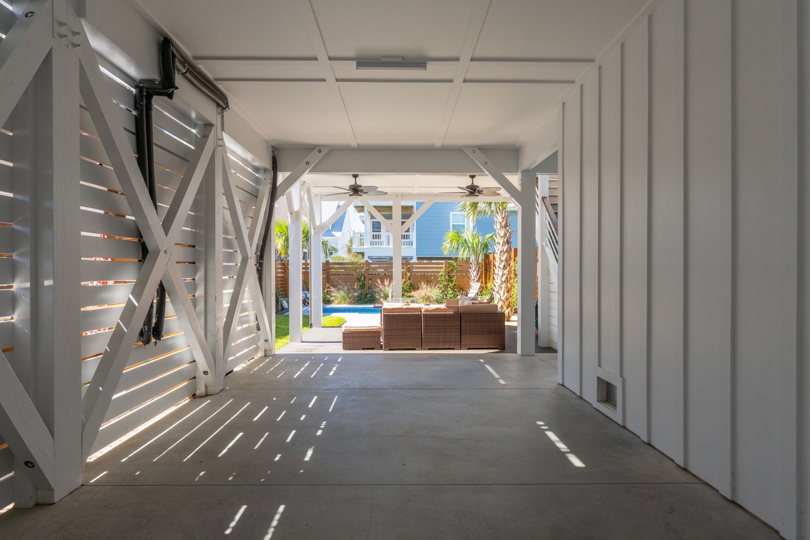 Step through your private covered entryway where tropical breezes filter through elegant louvers, leading to your sun-drenched pool paradise.