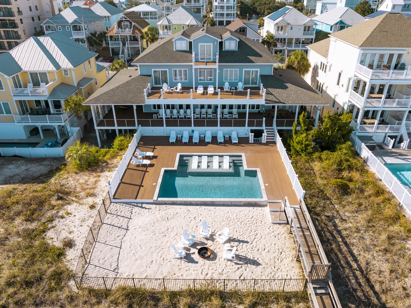 Stunning coastal property featuring a private pool, fire pit, and expansive decking surrounded by beach cottages in this vibrant waterfront community.
