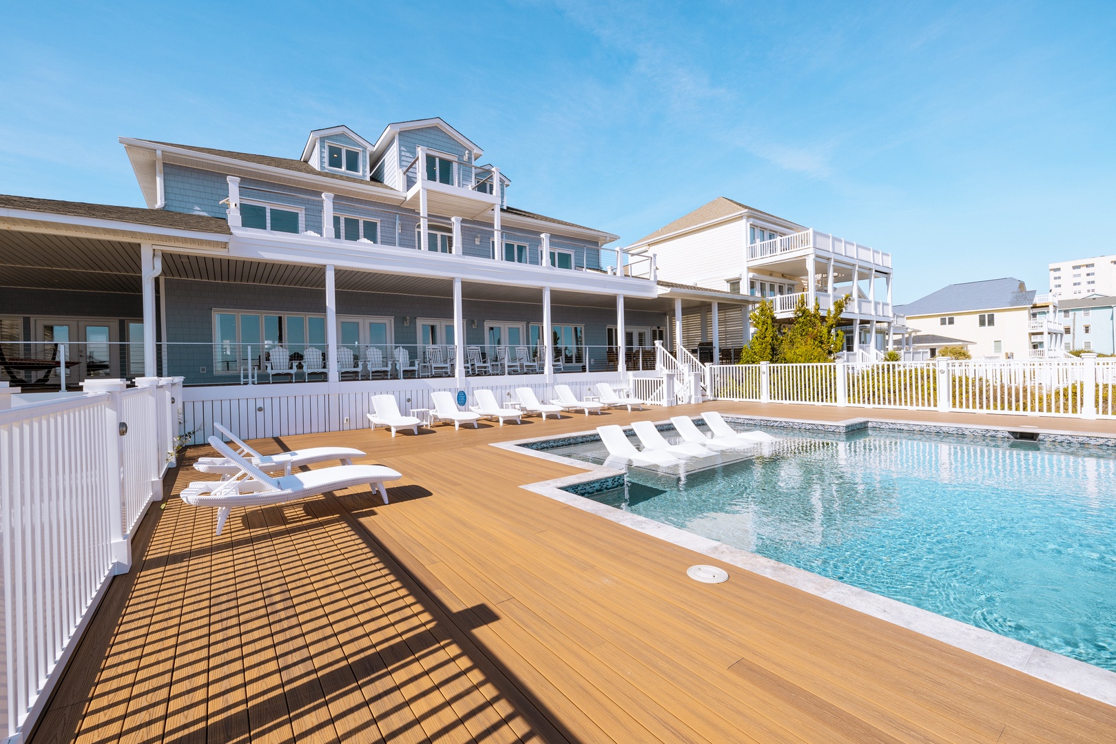 Expansive beachfront property featuring swimming pool, sun deck, and multiple levels of covered porches overlooking the coastal area.