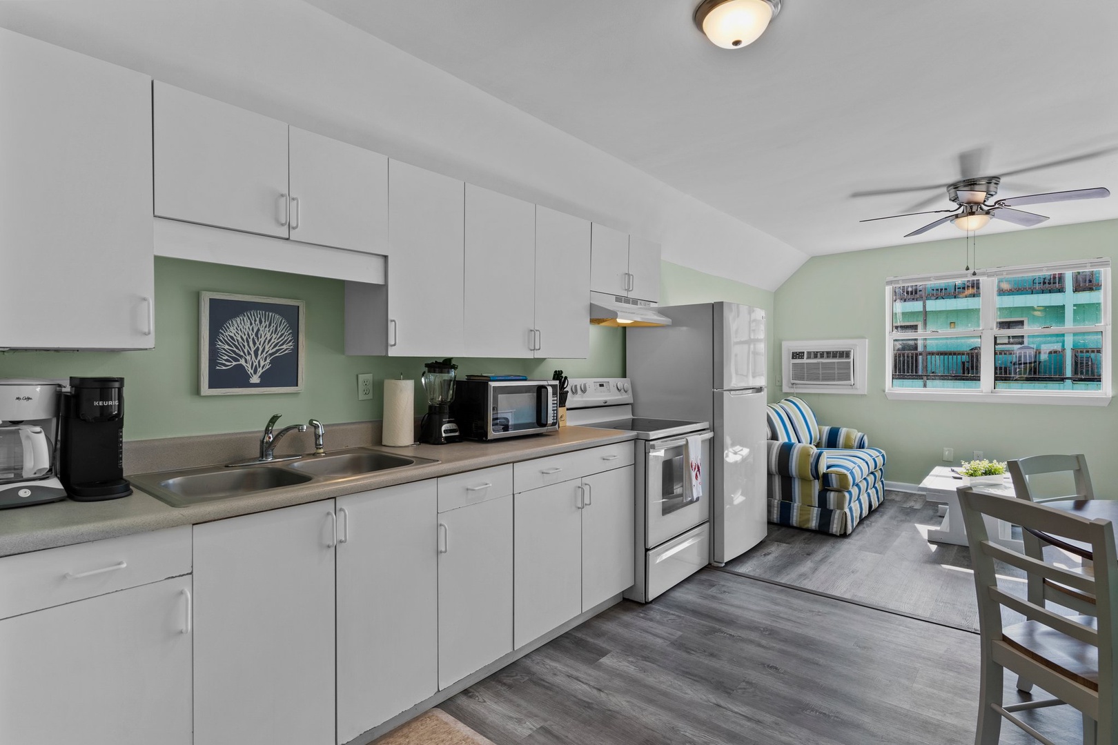 Unwind in your fully-equipped kitchen with modern appliances, perfect for preparing meals while enjoying the bright, airy atmosphere and comfortable seating area.