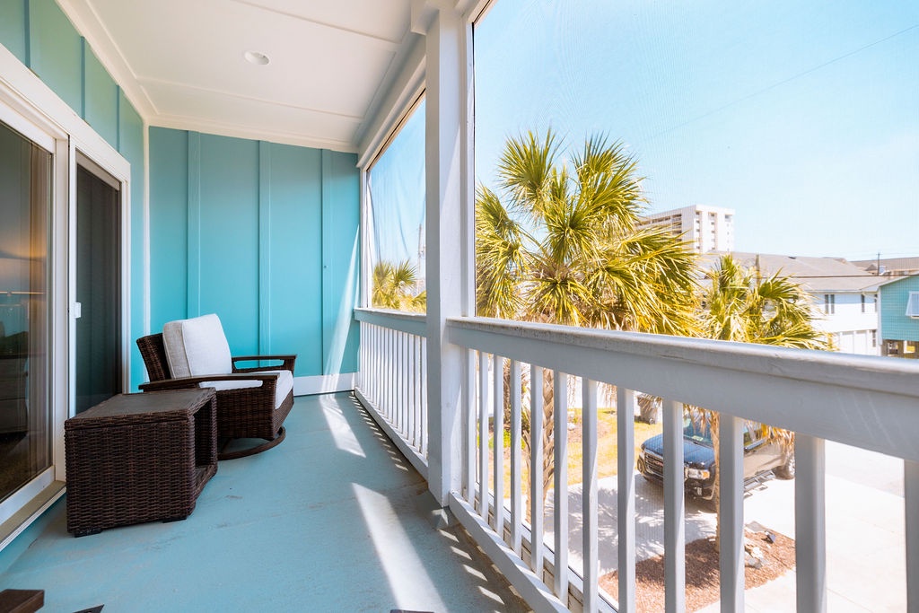 Relax on your private balcony with coastal views, where wicker seating and gentle ocean breezes create the perfect morning coffee retreat.