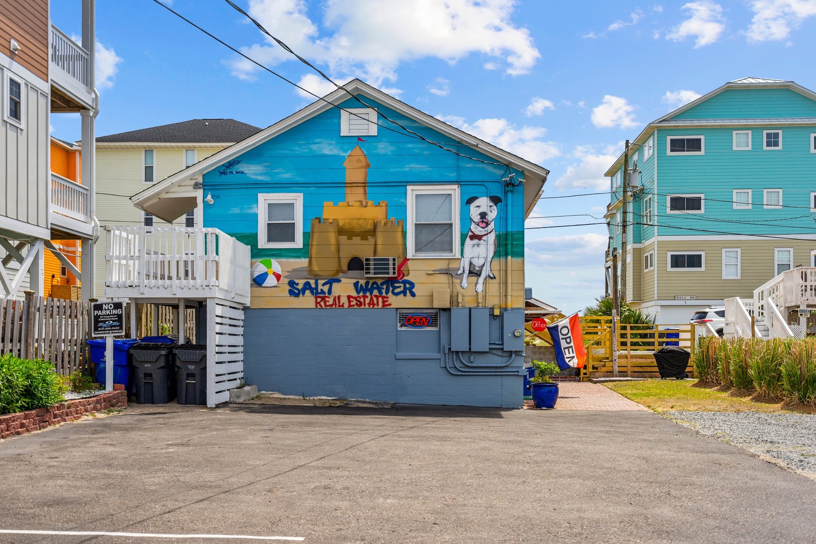 Colorful beachside real estate office surrounded by vibrant vacation rental homes in a charming coastal neighborhood.