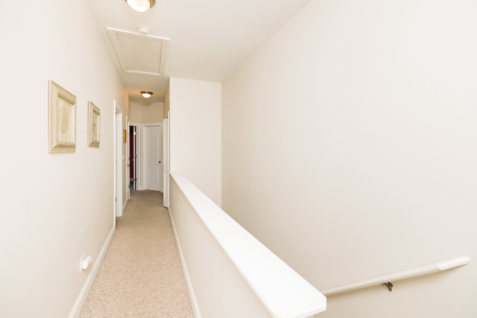 A bright, clean hallway with soft carpeting leads you to comfortable bedrooms, creating a welcoming pathway through your home away from home.