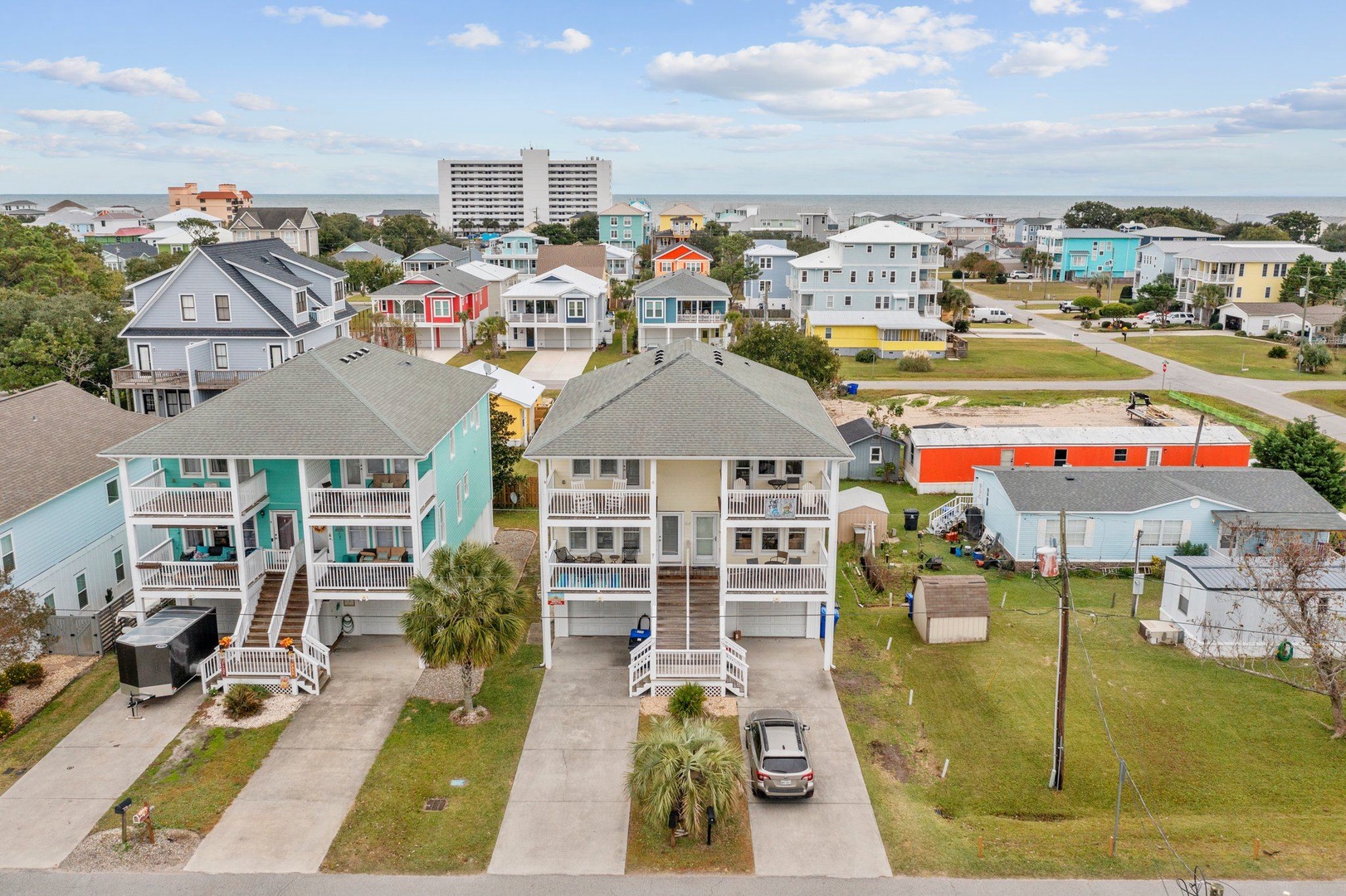 Aerial view of colorful coastal neighborhood showcasing charming beach houses and residential community near the shore.