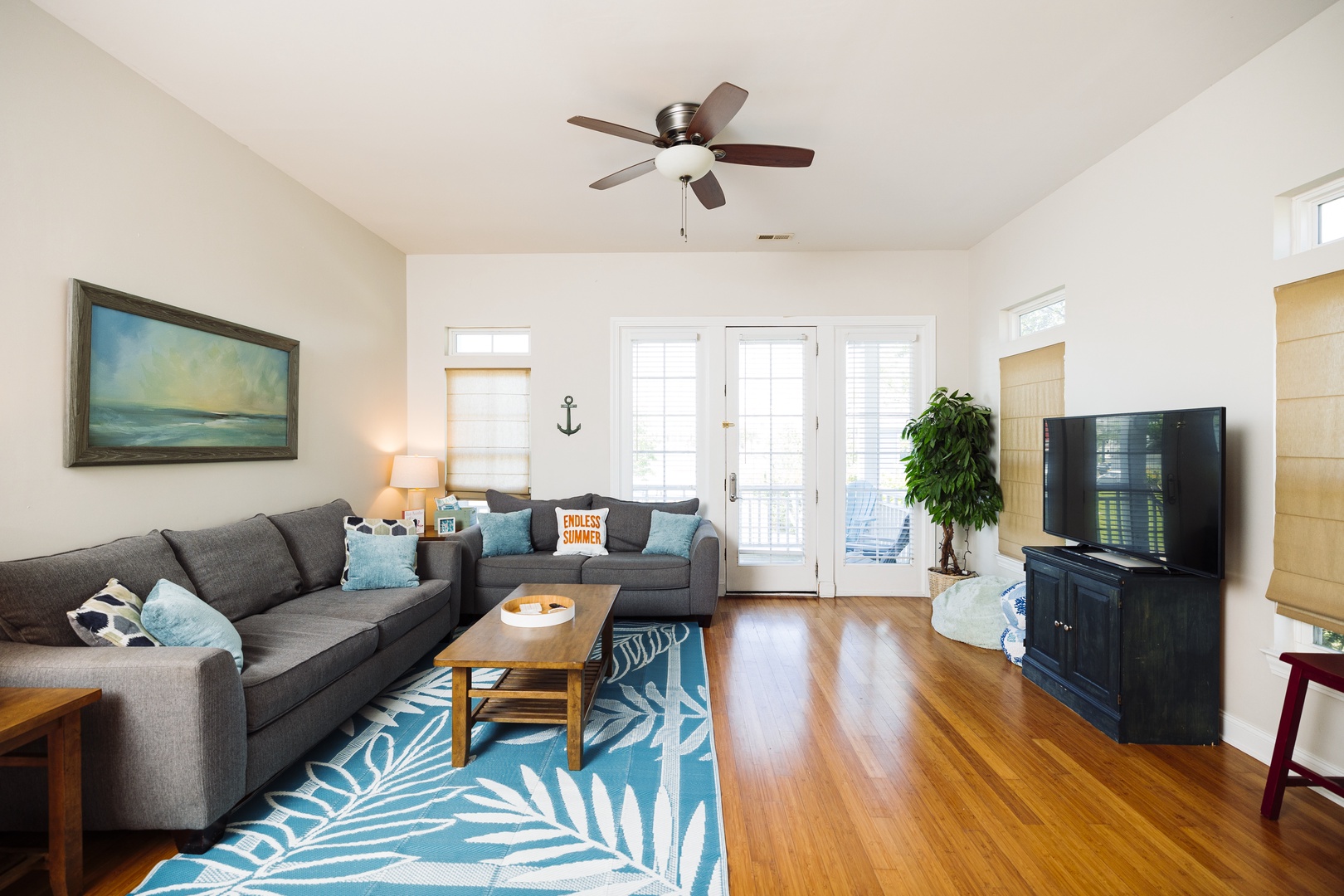 Settle into your cozy living space with comfy gray sectional seating and coastal touches that make you feel instantly at home.