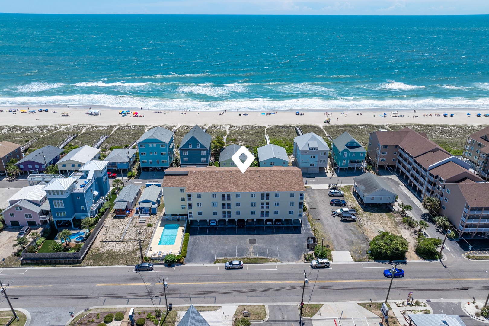 Beachfront property located steps from white sand and turquoise waves, with nearby coastal homes and ocean access just across the street.
