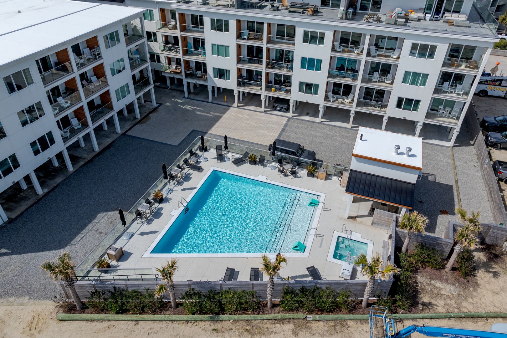 Modern apartment complex featuring a sparkling pool, hot tub, and contemporary accommodations in a well-designed residential development.