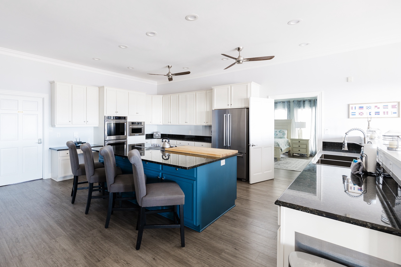 Your spacious kitchen features stainless steel appliances, granite countertops, and a striking blue island perfect for cooking and gathering.