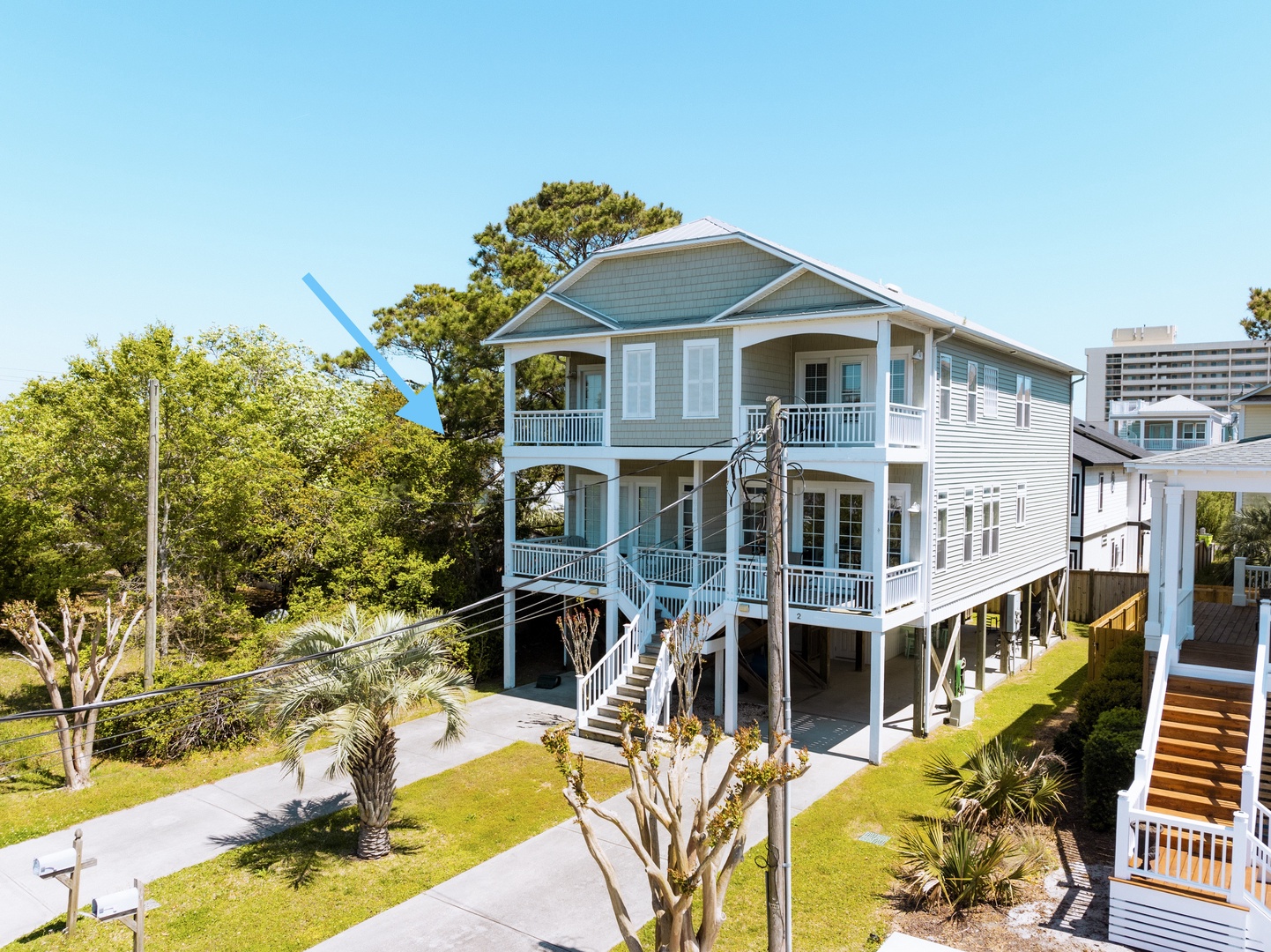 Charming coastal home with wraparound porches and tropical landscaping in a peaceful residential neighborhood.