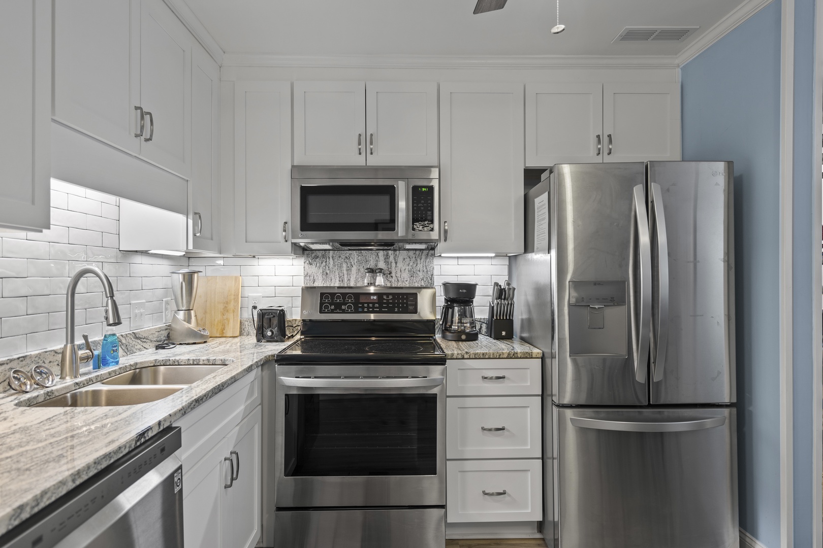 Cook your favorite meals in this bright, fully-equipped kitchen featuring stainless steel appliances and elegant granite countertops.