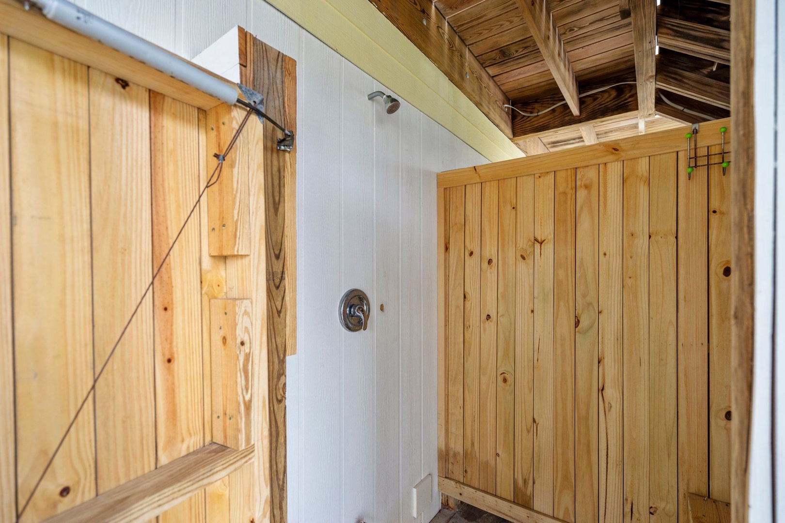 Your rustic outdoor shower blends natural wood with modern fixtures, creating the perfect spot to rinse off after beach days.