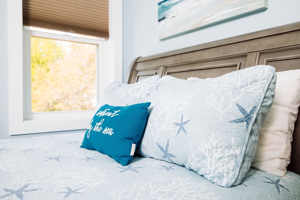 Sink into coastal comfort with soft starfish-printed bedding and ocean-inspired pillows that invite peaceful dreams by the sea.