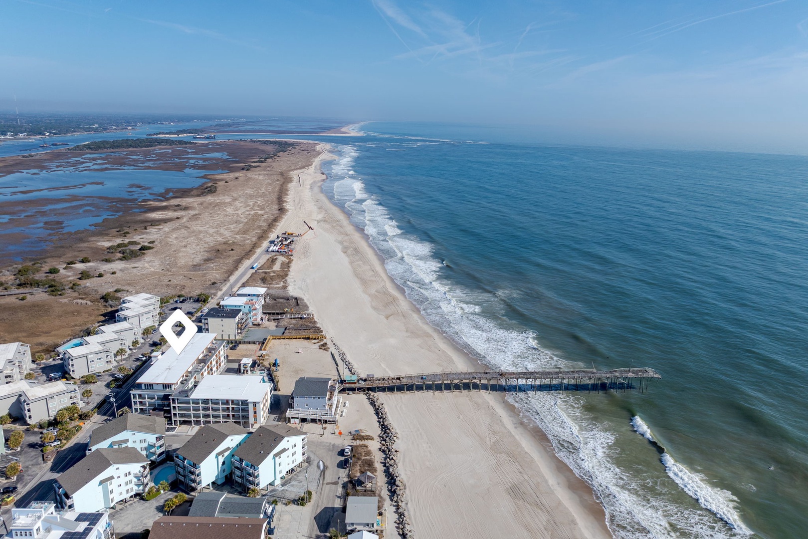 Stunning aerial view of pristine coastline with sandy beaches stretching along turquoise waters and charming beachfront properties.
