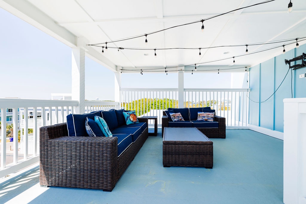 Relax on your private terrace with navy wicker seating and twinkling lights overhead, watching the world below.
