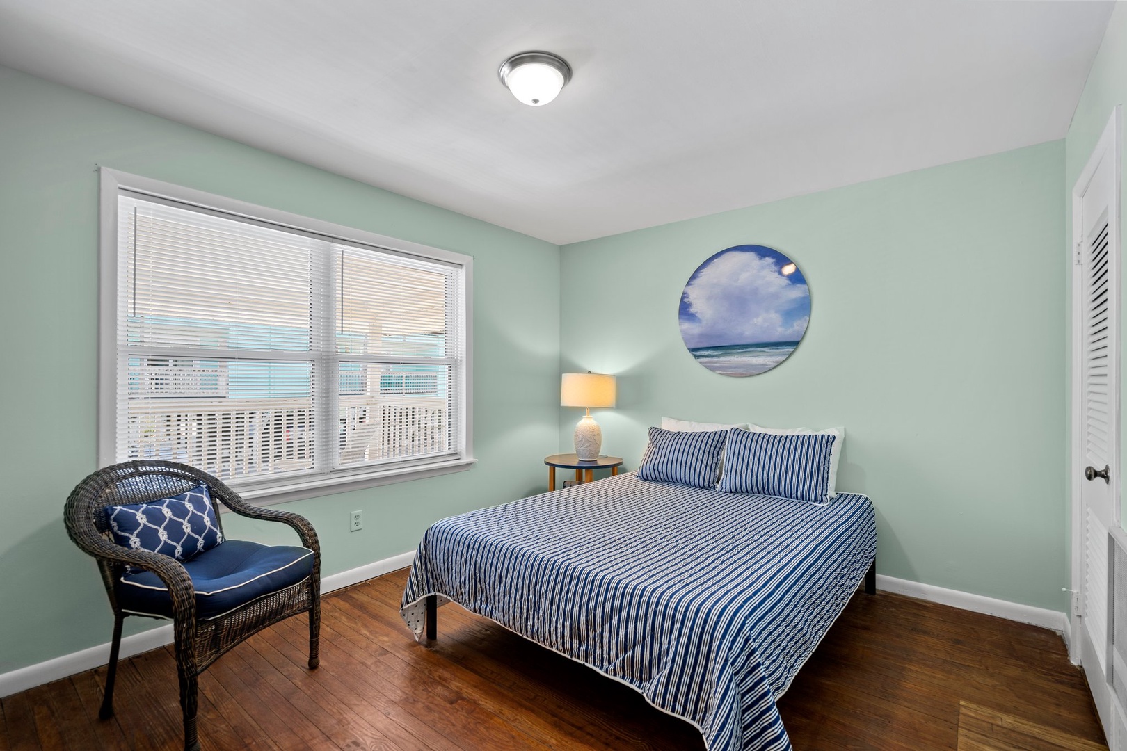 Drift off peacefully in this soothing coastal bedroom with soft mint walls and ocean-inspired decor.