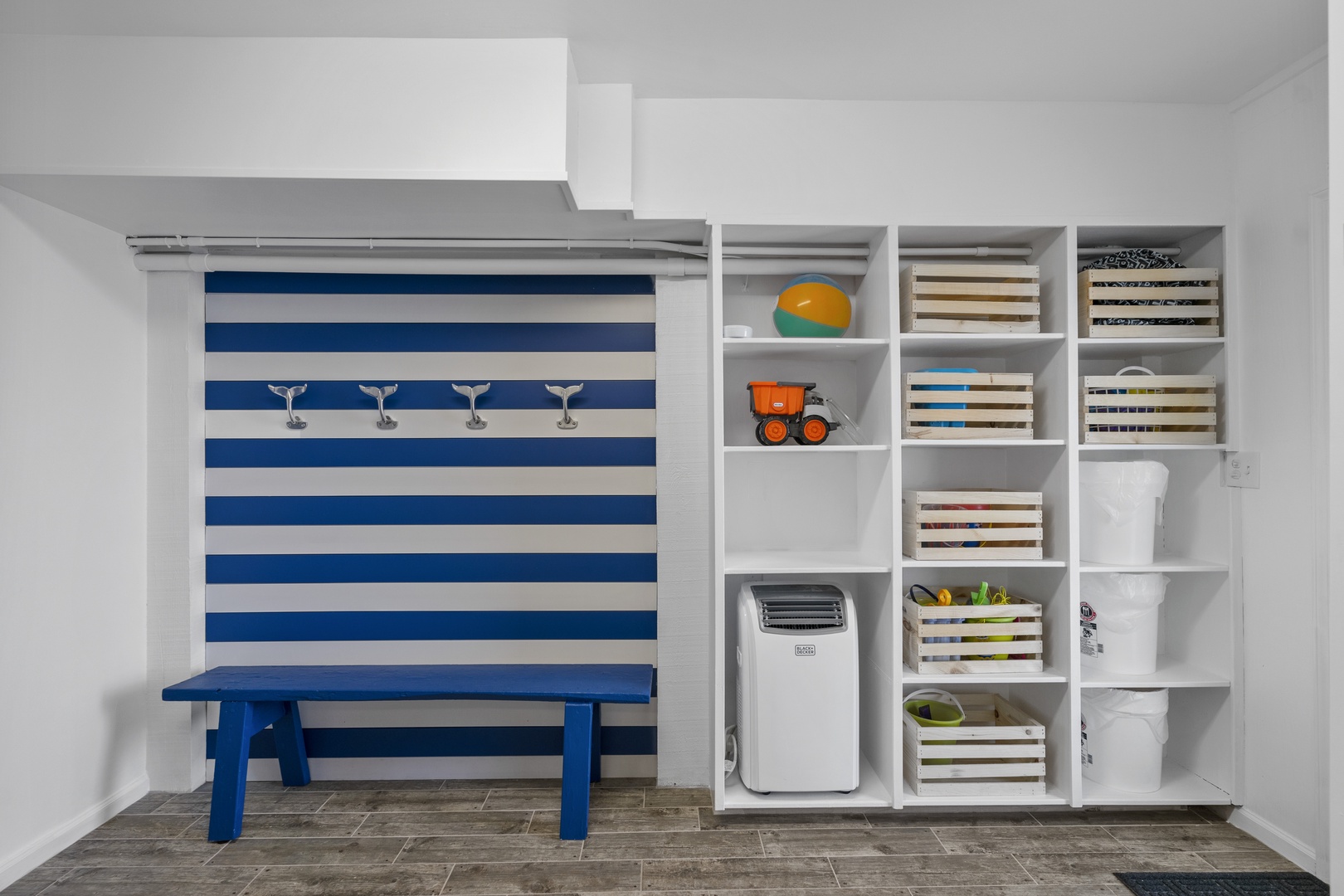 Your bright playroom offers organized storage cubbies, toys, and a cheerful workspace with nautical touches.