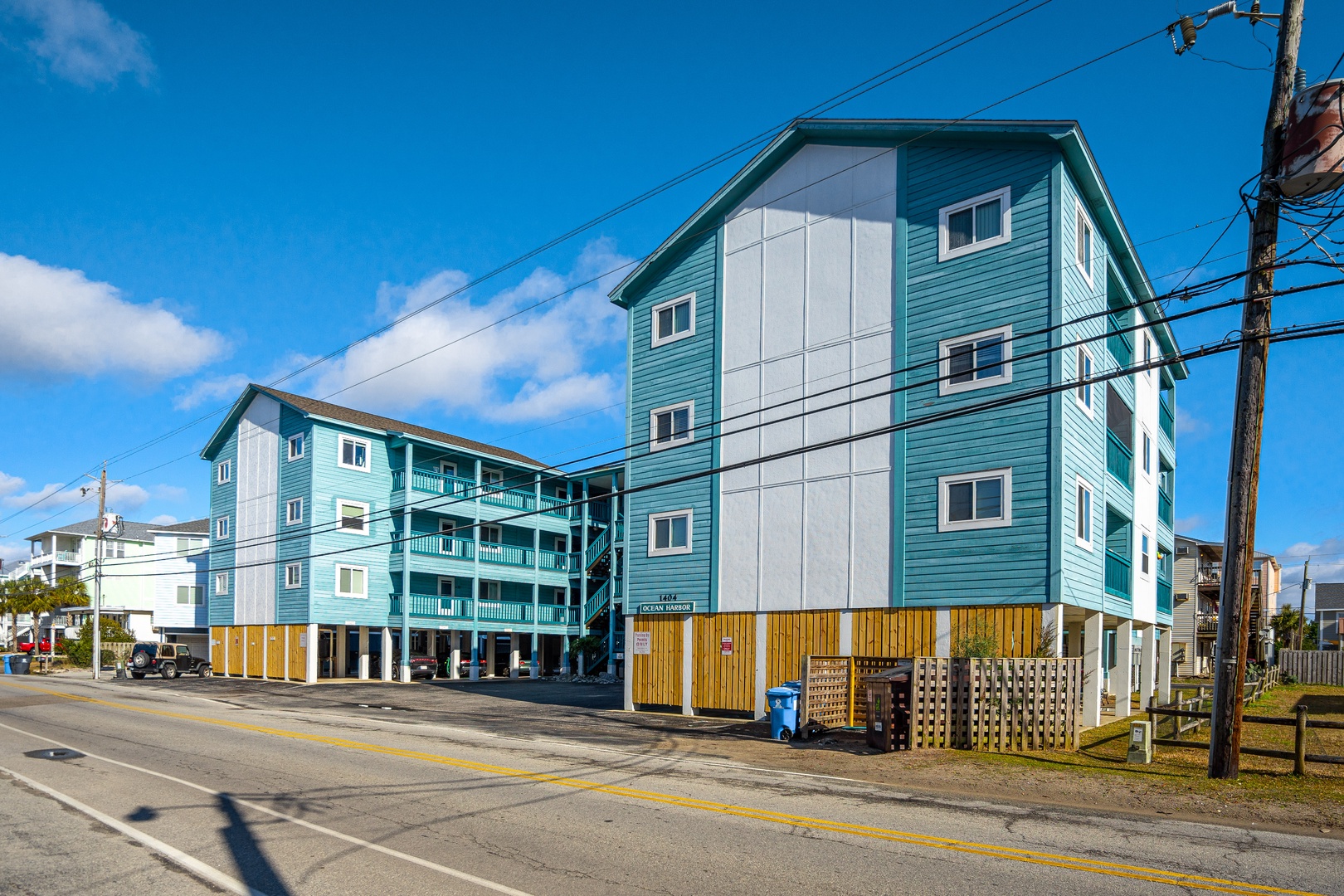 Bright turquoise vacation rental buildings create a cheerful coastal atmosphere in this beachside community setting.