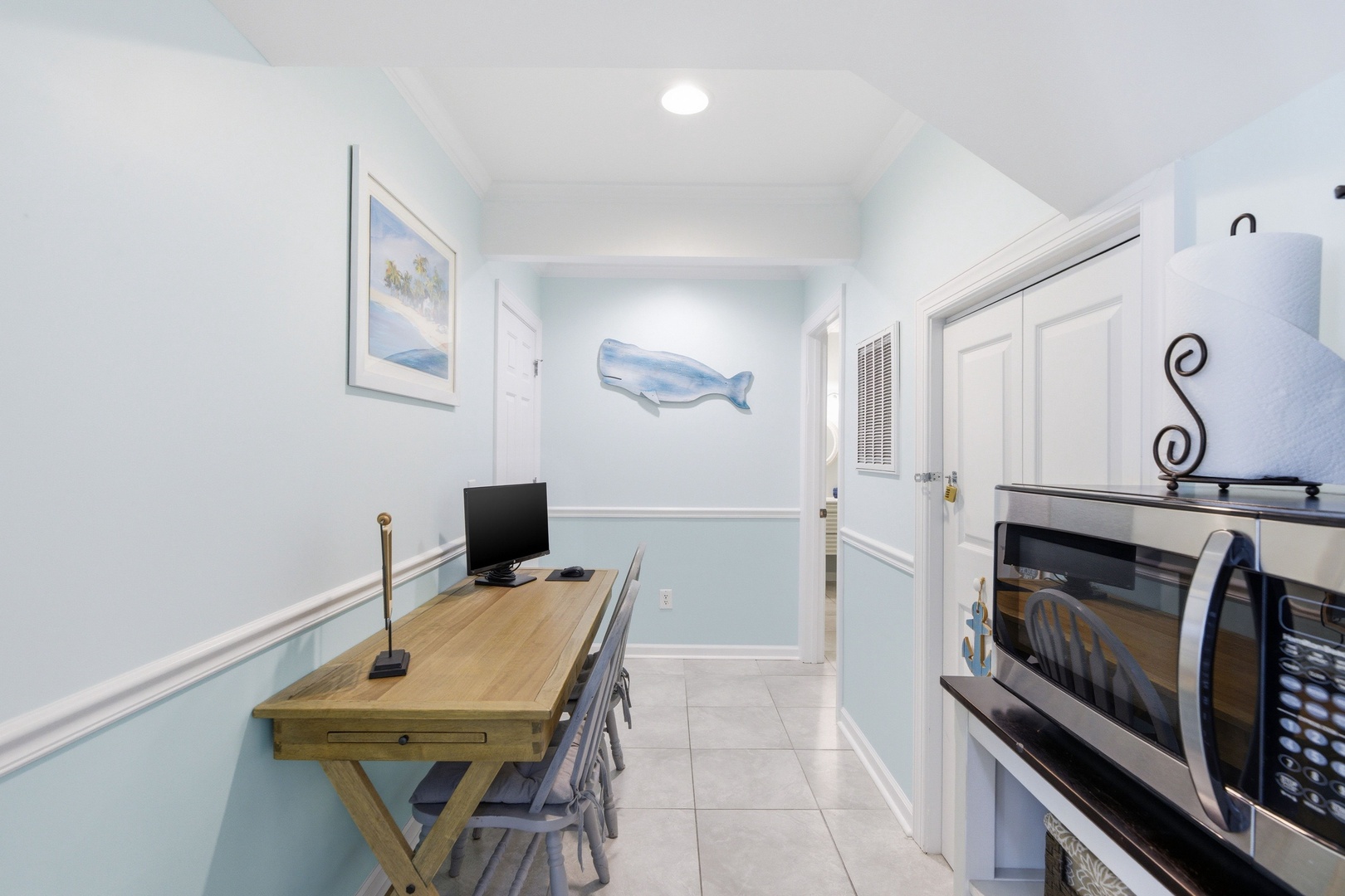 Your coastal workspace awaits with charming nautical touches, a bright wooden desk, and modern conveniences including a microwave—perfect for quick meals between beach adventures.