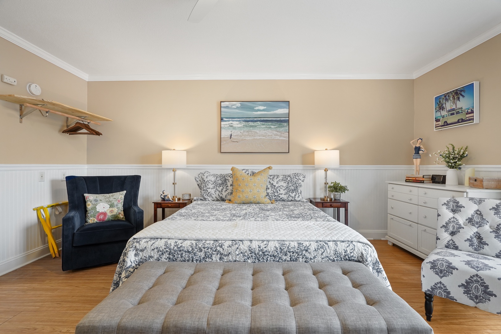 Your comfortable bedroom features coastal artwork and cozy seating, creating the perfect retreat after exploring the area.