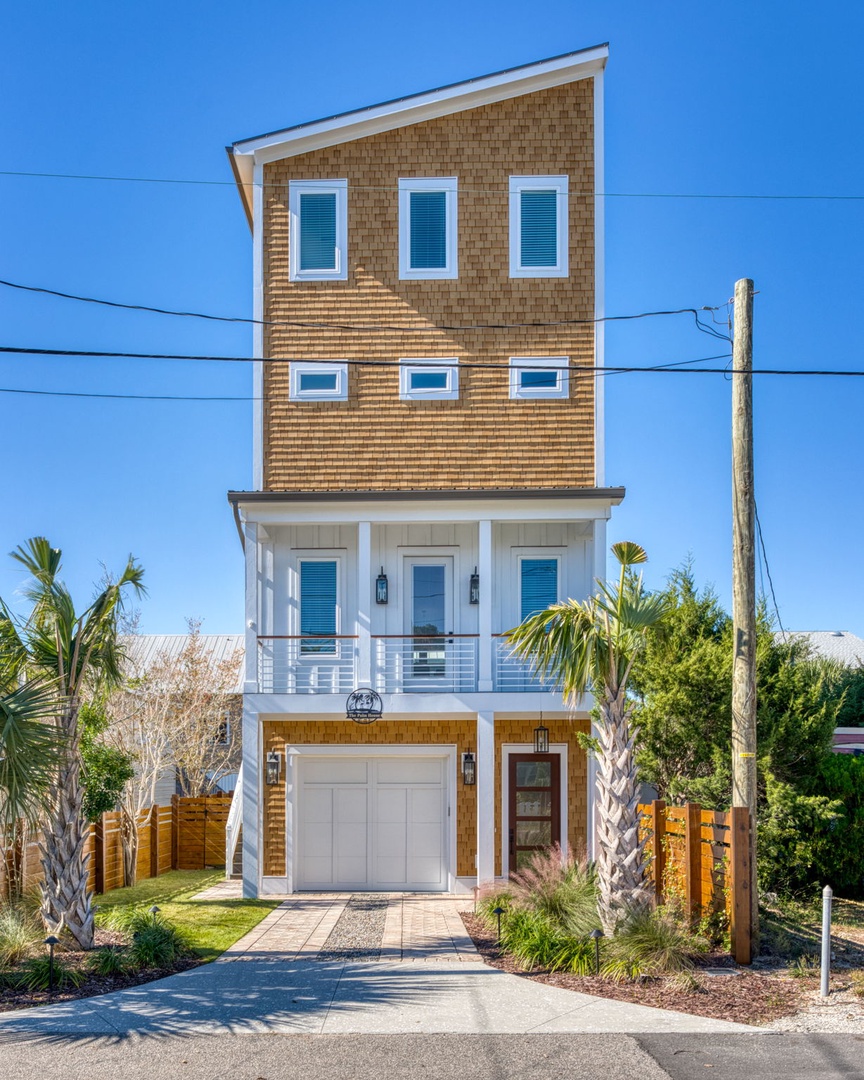 Modern coastal home with wood siding and palm trees creates a perfect beachside retreat.