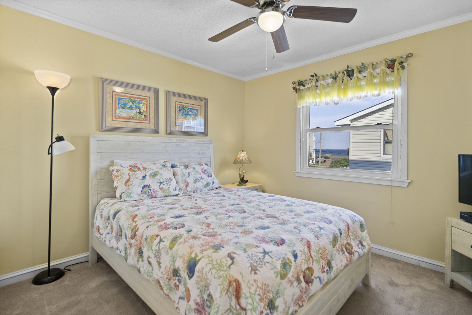 Wake up to ocean views from your cozy bedroom, complete with charming coastal artwork and gentle sea breezes through the window.