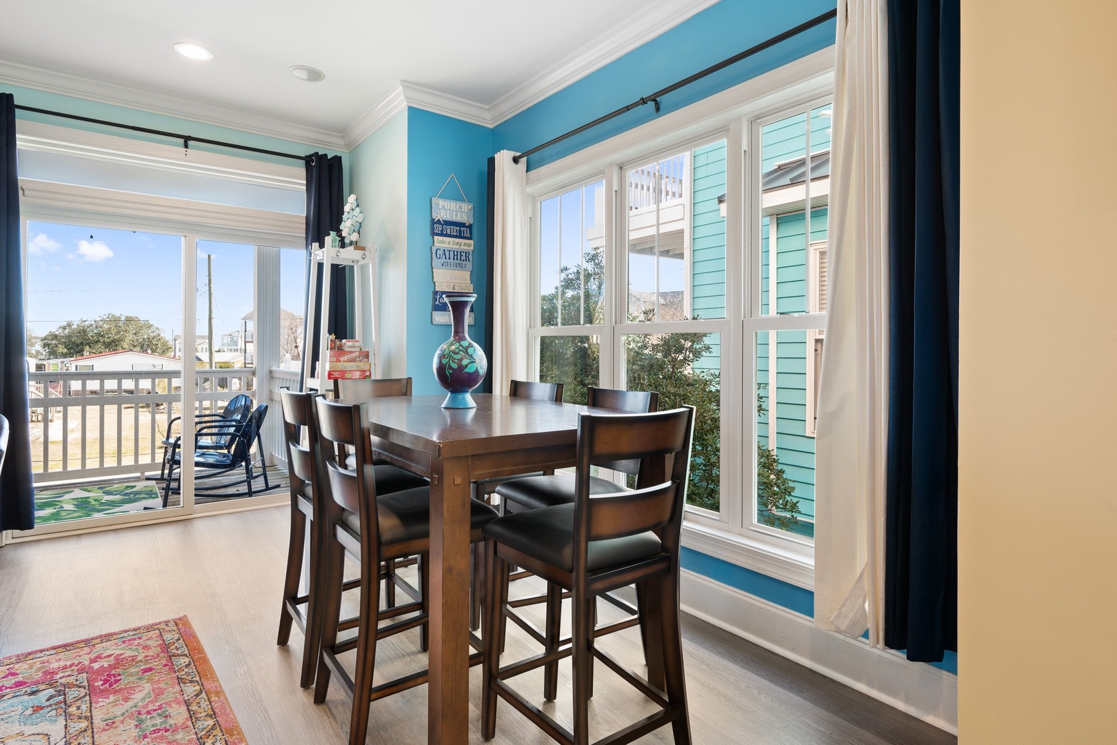 Gather around this charming dining table while sunlight streams through windows, offering lovely views of the surrounding neighborhood.