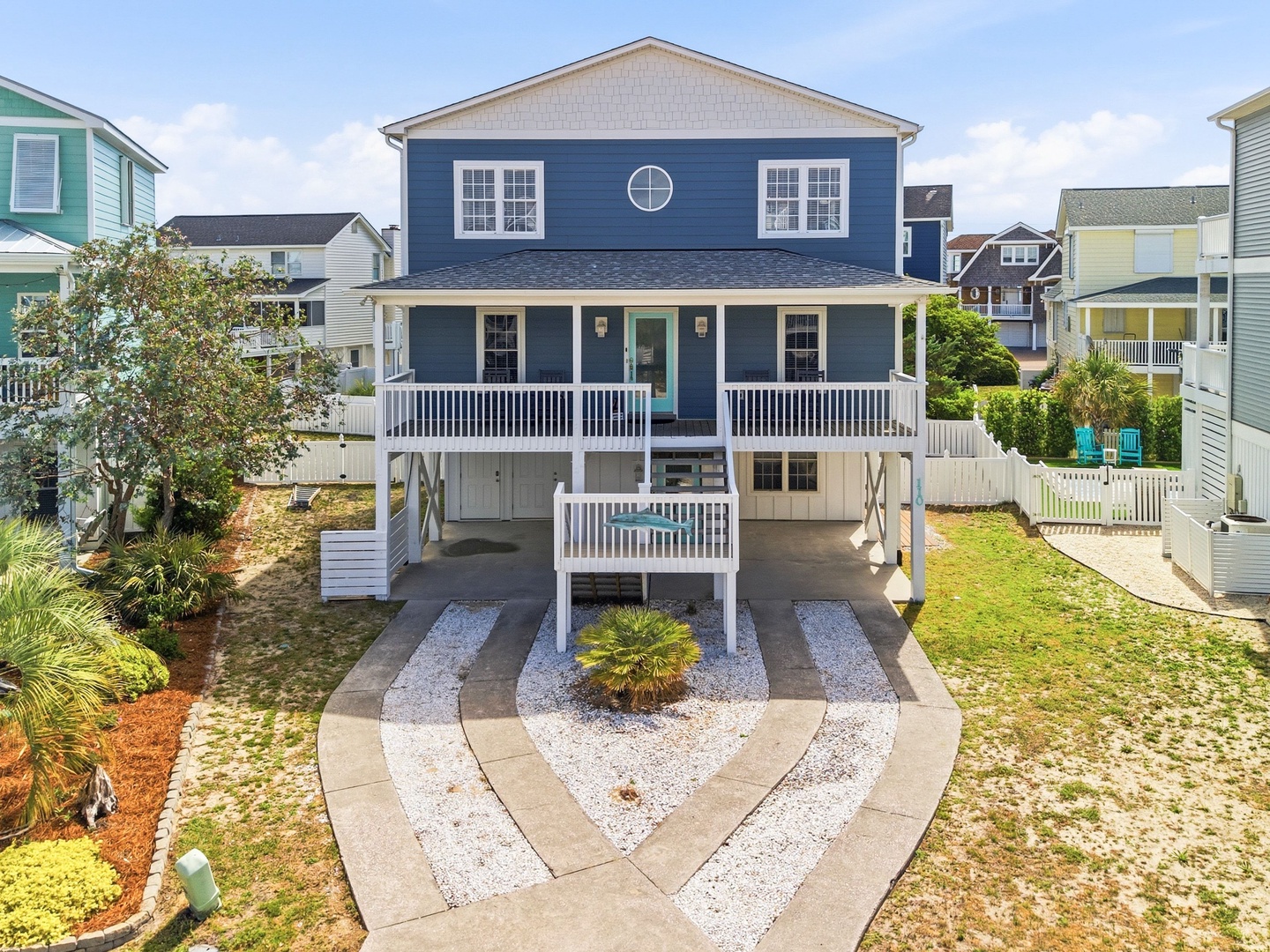 Charming coastal home in a friendly neighborhood, featuring a welcoming front porch and beautifully landscaped yard—ideal for a relaxing beach getaway.