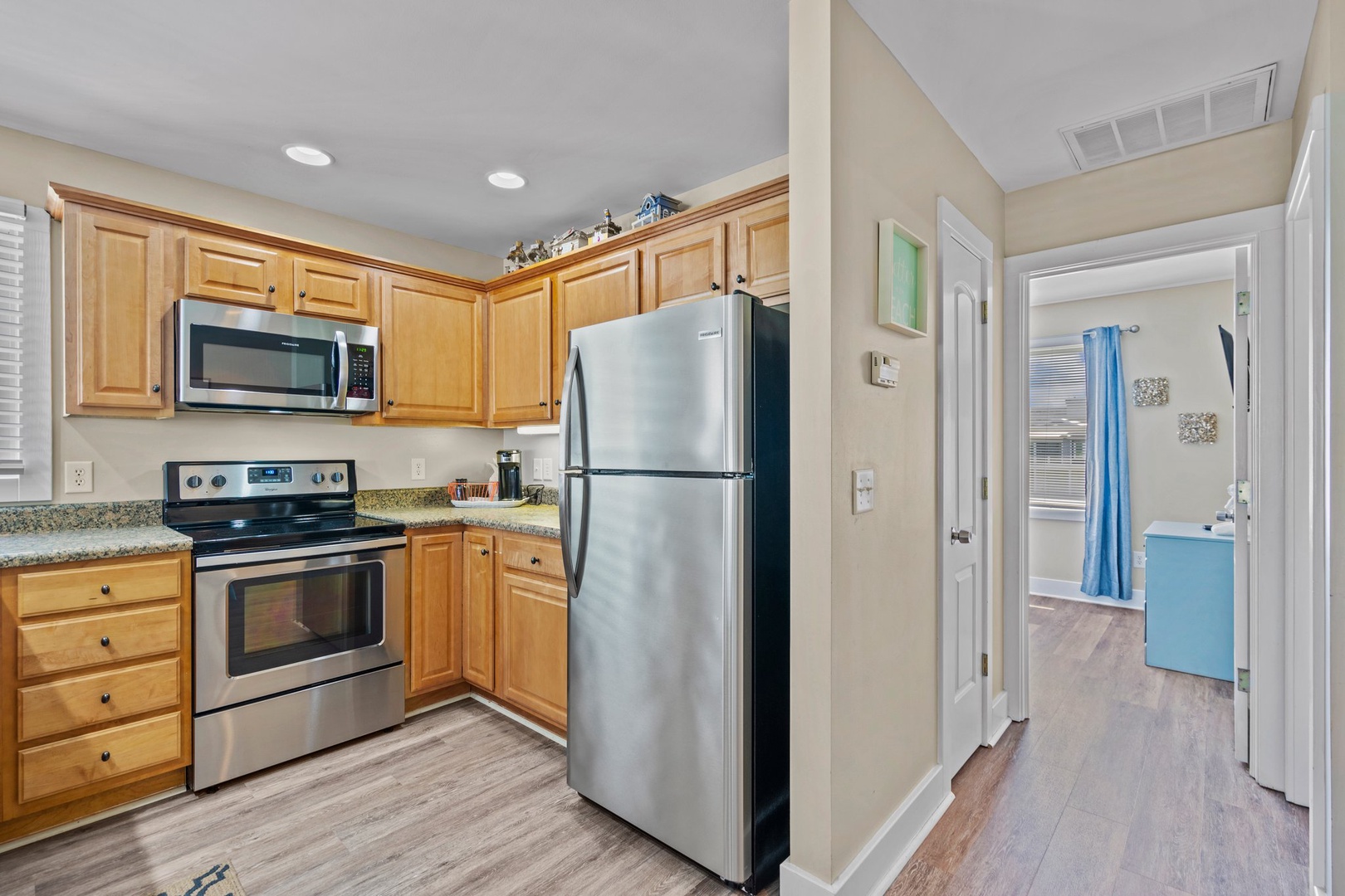 Your fully equipped kitchen features stainless steel appliances and warm wood cabinetry, perfect for preparing meals during your stay.