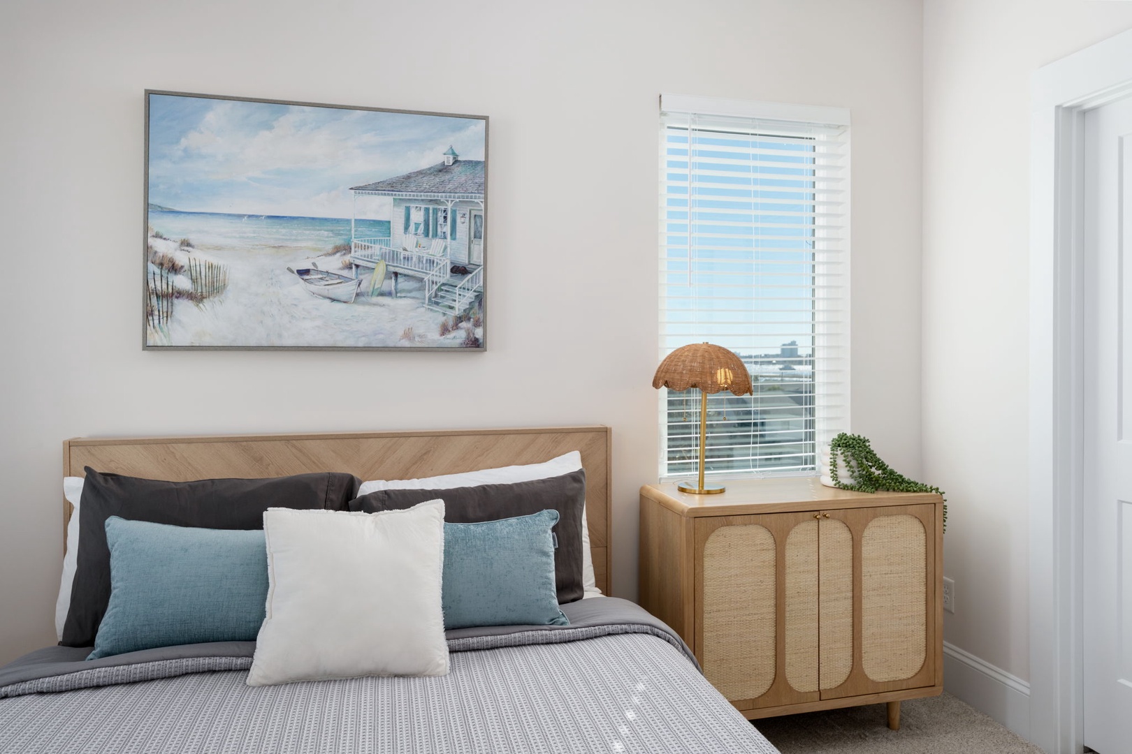 Sink into comfort with crisp linens and coastal artwork creating your perfect seaside retreat.