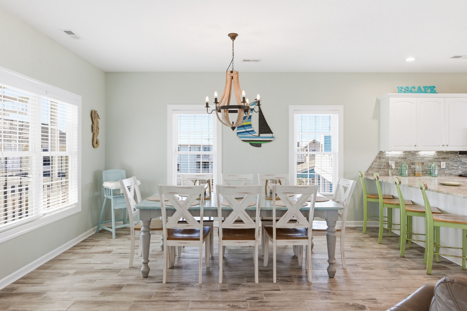 Gather everyone around this spacious dining table for memorable meals together, bathed in natural light from large windows. The adjoining kitchen island offers extra seating and easy entertaining.