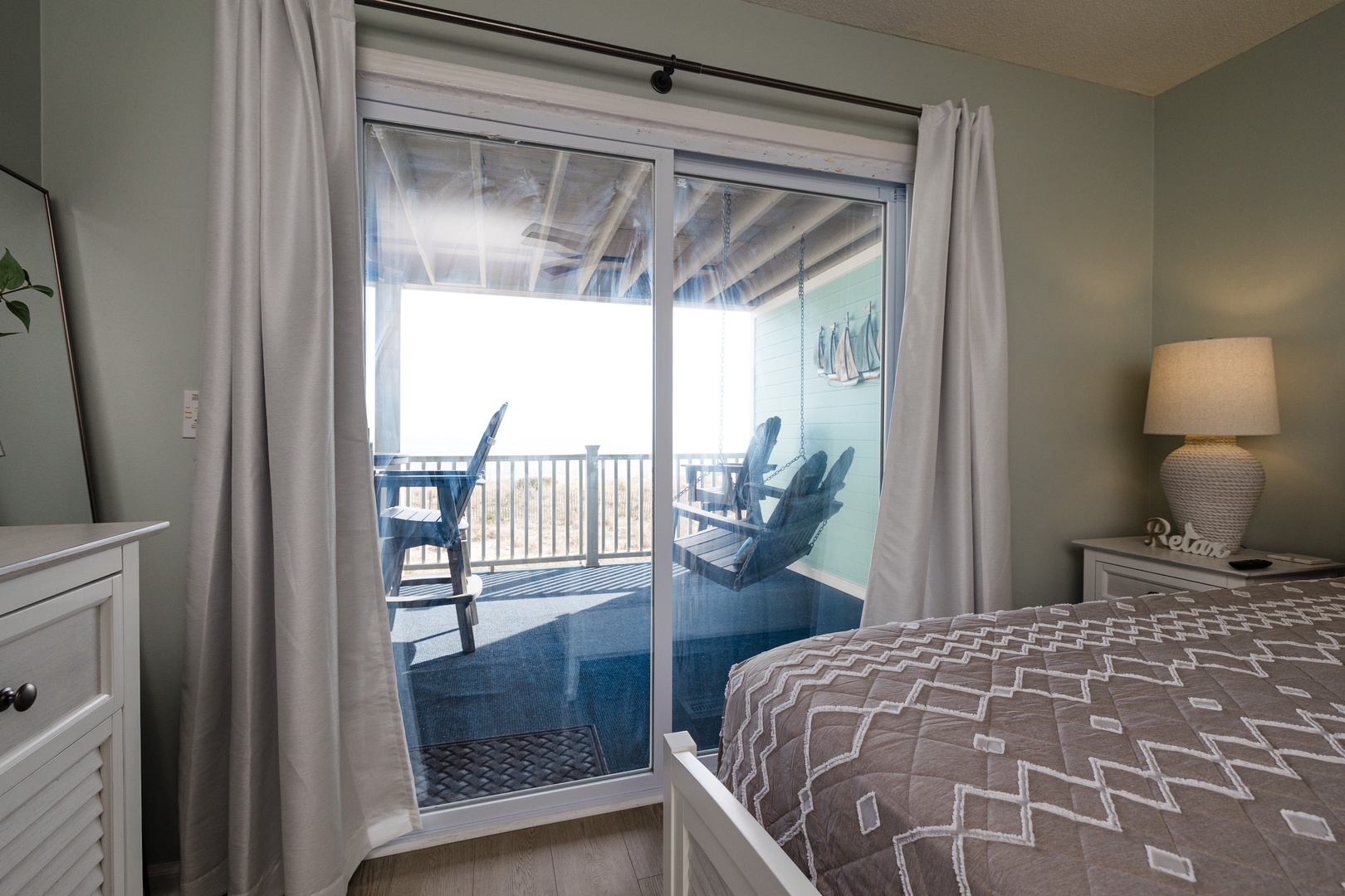 Wake up to serene water views from your cozy bedroom, where sliding doors open to a private balcony overlooking peaceful waters.
