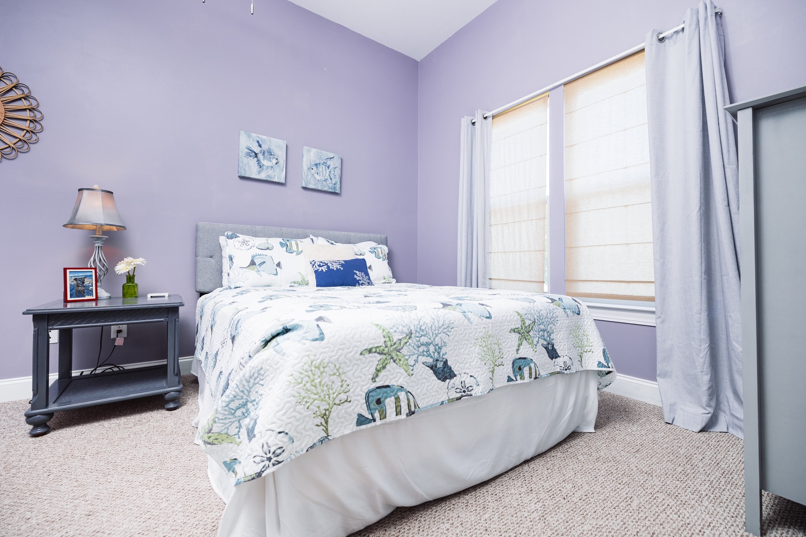 Drift into peaceful sleep in your serene lavender bedroom, where ocean-themed linens and soft natural light create the perfect coastal retreat.