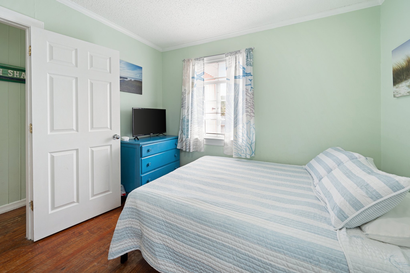 Unwind in your peaceful bedroom with soft mint walls, comfortable bedding, and natural light from the window.