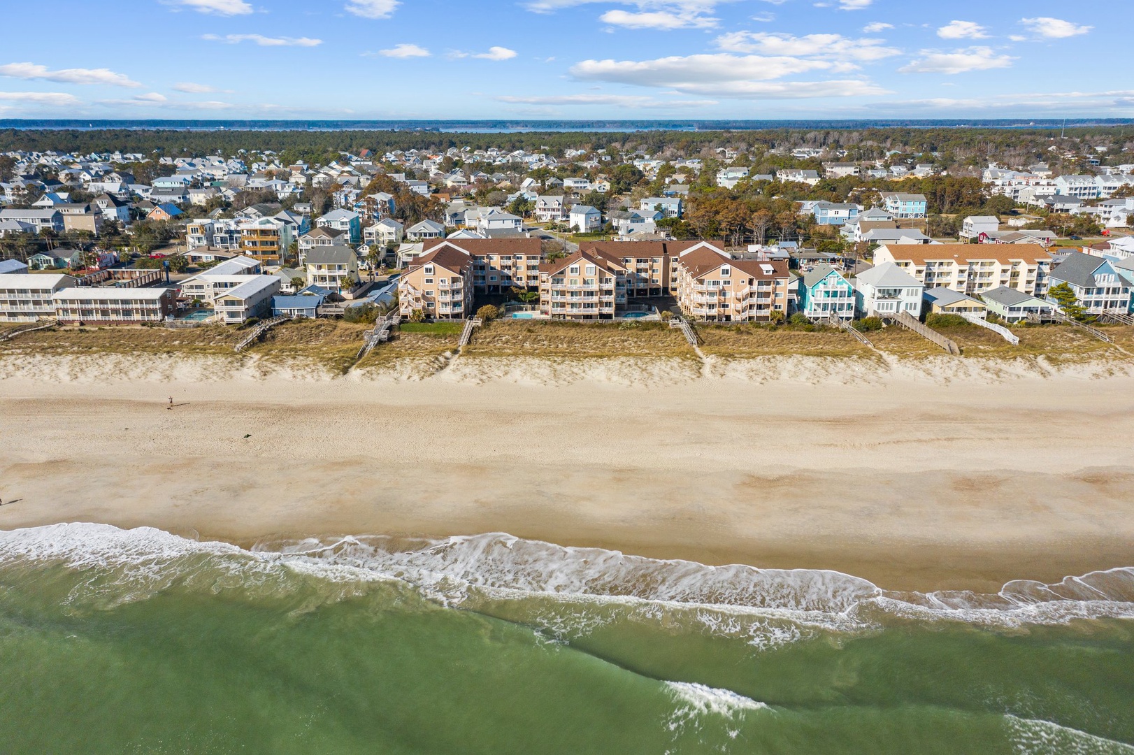 Beachfront community nestled between pristine sandy shores and coastal neighborhood, offering direct beach access and ocean proximity.
