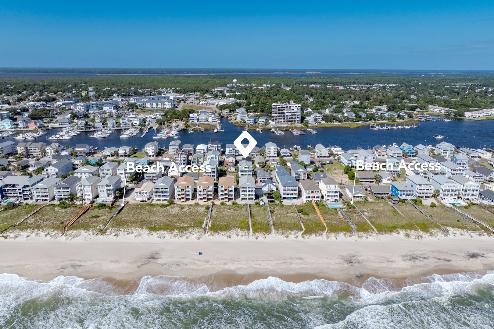 Aerial view showcasing beachfront properties with direct beach access and nearby marina facilities in a coastal community.