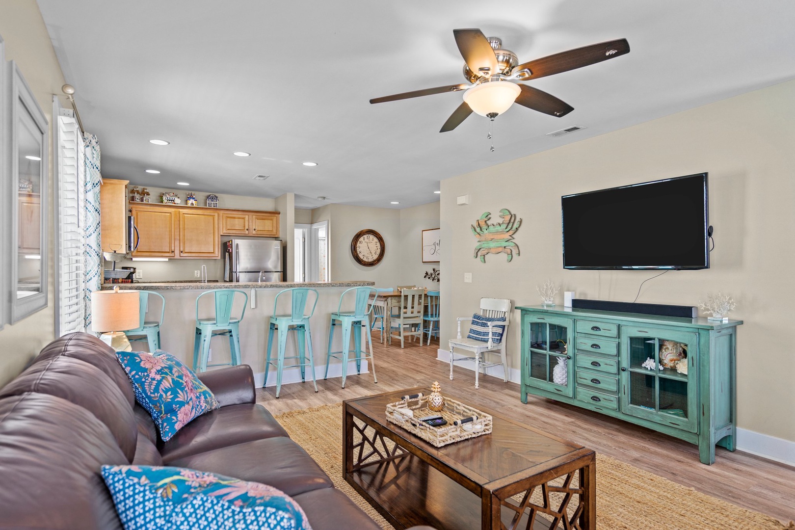 Relax in your coastal-themed living space with comfortable seating, a large TV, and an open kitchen perfect for vacation meals.