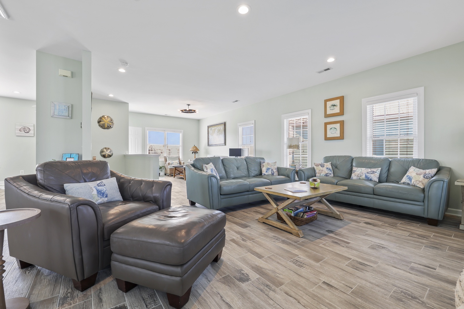 Step into your spacious retreat with coastal charm, featuring plush seating, soothing blue-gray tones, and bright windows that bathe the room in natural light—perfect for gathering with loved ones.