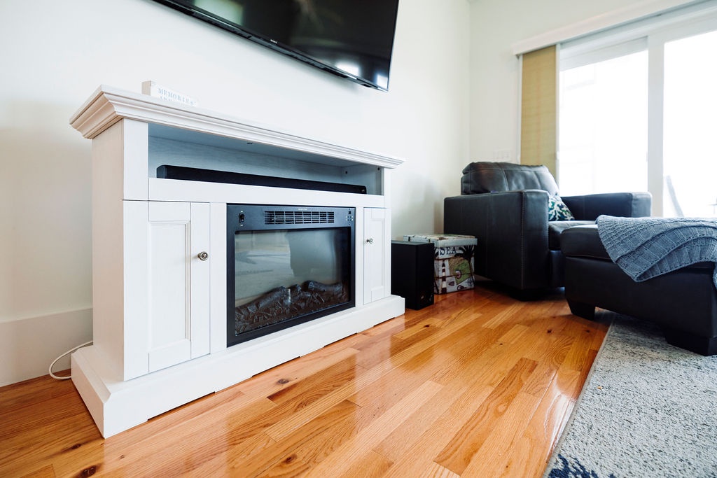 Cozy up by your electric fireplace while watching TV in this comfortable living space with beautiful hardwood floors.