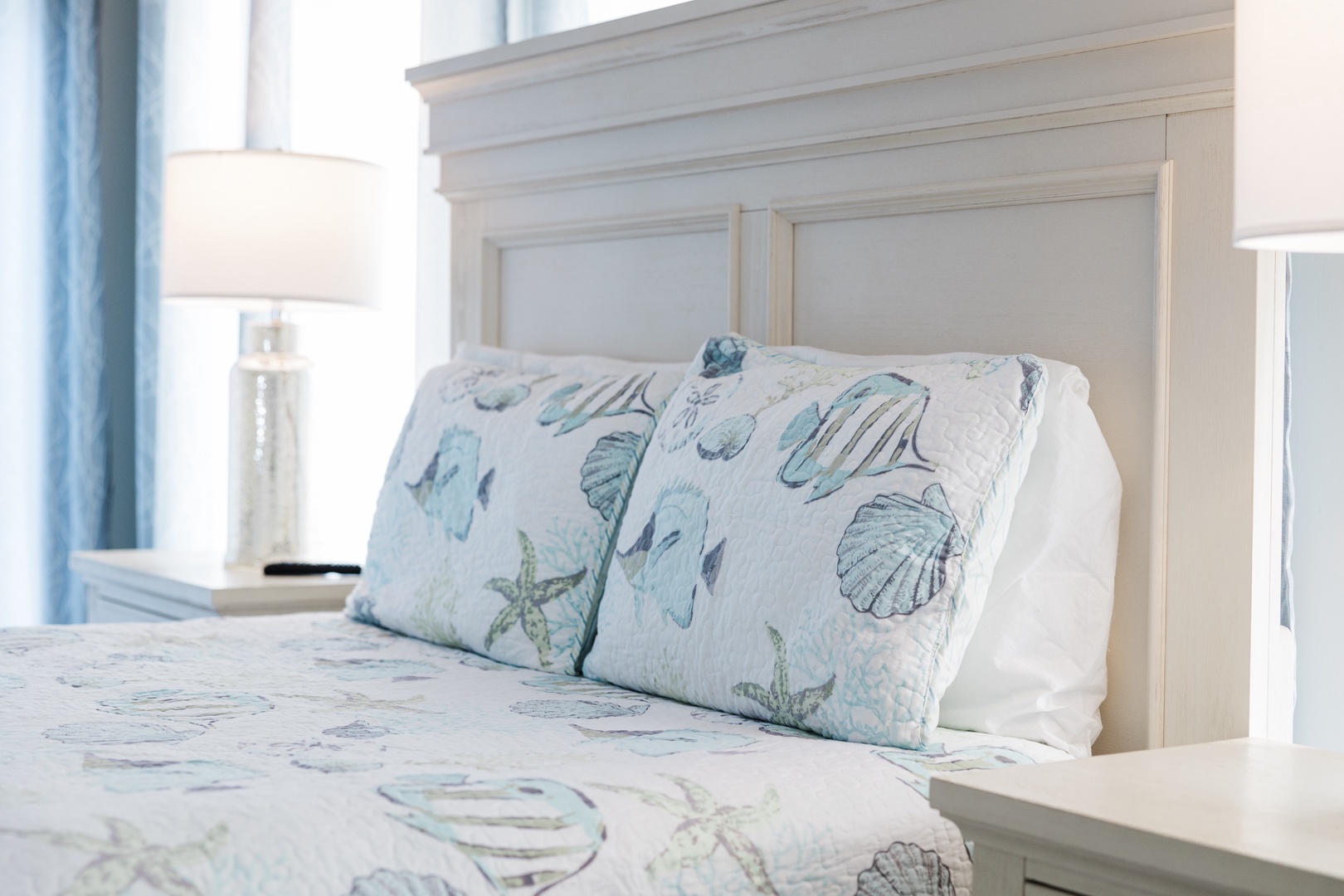 Drift off to peaceful dreams on soft linens adorned with charming seashells and starfish, creating your own coastal sanctuary.