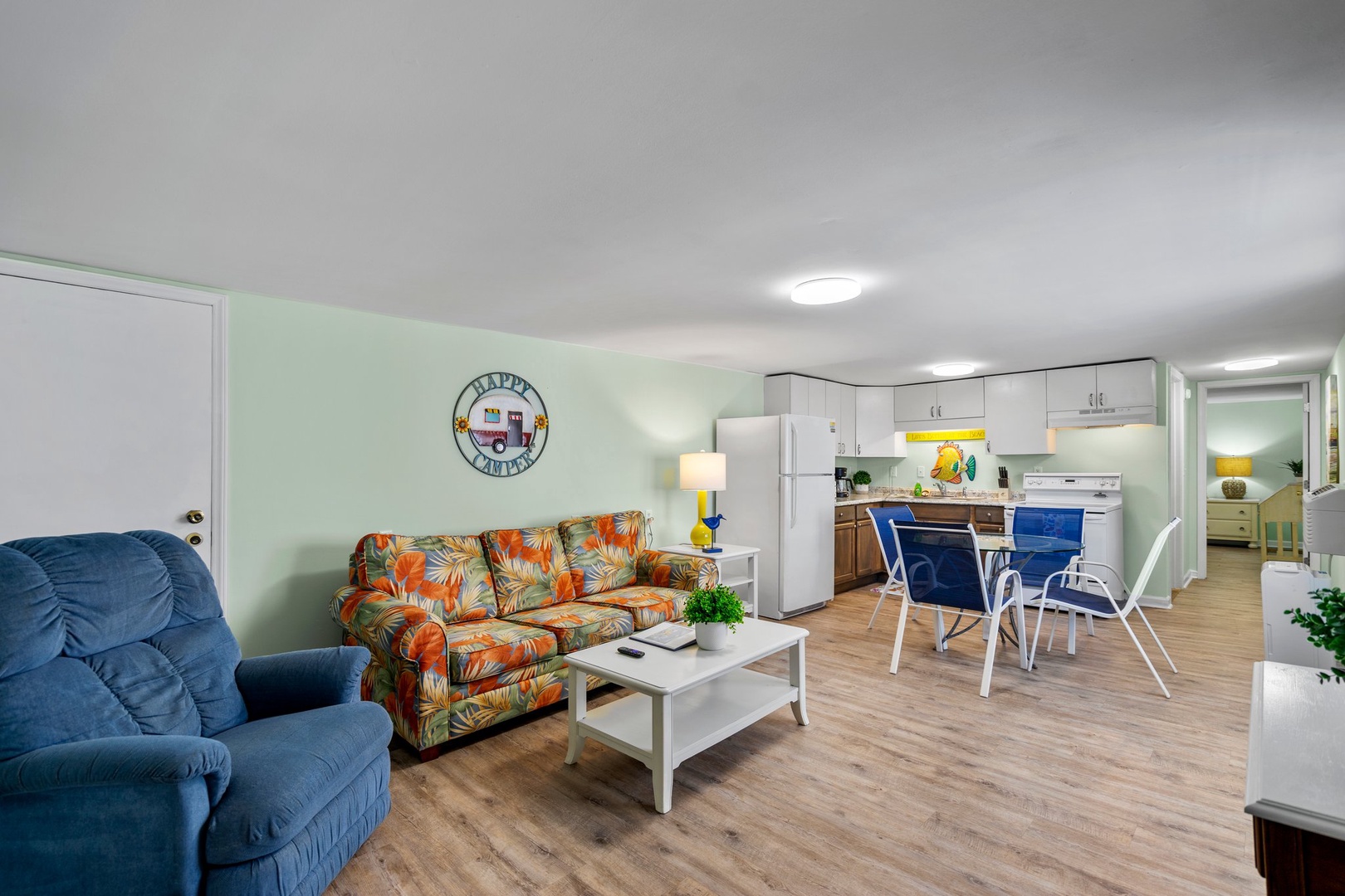 Relax in your bright, open-concept space with tropical-print sofa, full kitchen, and cheerful coastal decor that makes you feel instantly at home.