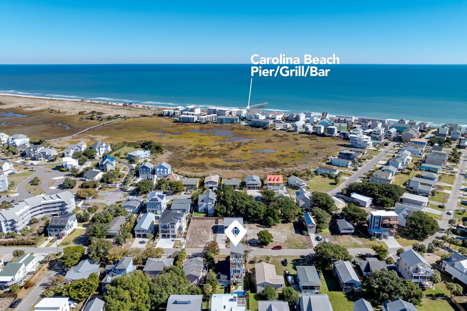 Aerial view of the charming Carolina Beach neighborhood with the famous pier and beachfront dining just steps away.